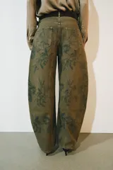 Jeans de tiro bajo y diseño barrel leg de la colección Zara Woman, en color verde militar con estampado floral en contraste, trabillas para cinturón y costuras decorativas frontales.