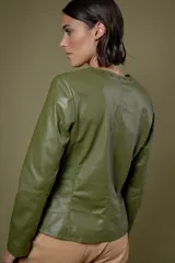 Campera de cuero color camel, con cuello redondo, cierre frontal y detalles de tachas metálicas en el cuello y bolsillos laterales.