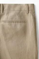 Pantalón de traje de lino color tostado, corte slim fit con piernas de corte recto, pinzas marcadas y trabillas para cinturón.