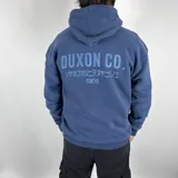 Canguro azul con capucha, corte oversize y estampado en el frente con la leyenda "Duxon Co." en letras mayúsculas, seguido de texto en japonés y la palabra "Tokyo".