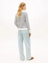 Sweater de punto de puro algodón orgánico con diseño a rayas horizontales en color blanco, azul marino y celeste. Presenta cuello en V, mangas largas con puños acanalados y el logo bordado de Tommy Hilfiger en el pecho.