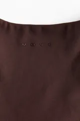 Remera deportiva cropped H&M Move en tejido funcional marrón, con mangas cortas, escote en V y detalle de nudo girado en el frente.