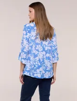 Blusa liviana de cuello mao con estampado floral en tonos azul y blanco, manga tres cuartos con presilla para arremangar, bolsillos frontales con solapa y cierre de botones nacarados.