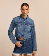 Campera de jean de calce regular, con cuello inglés, abotonado delantero, bolsillos fake en el pecho con solapa y recortes.