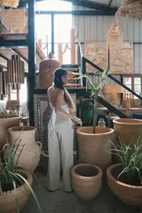 Pantalón de corte recto y tiro alto, confeccionado en lino color blanco. Presenta cierre frontal con botón y bolsillos laterales.