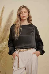 Blusa de satén color champagne con cuello a la base, mangas anchas y puños elásticos con detalle bordado.