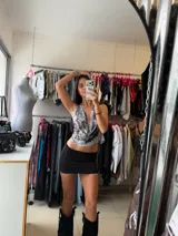 Top de cuello halter con escote pronunciado y diseño drapeado, estampado en tonos grises y blancos con efecto marmolado.