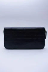 Billetera negra con textura símil cocodrilo, cierre perimetral con cremallera, múltiples ranuras para tarjetas, documentos y billetes, y bolsillo interior con cierre para monedas. Forro textil rojo.