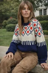 Sweater de lana merino con estampado Fair Isle en tonos azul marino, beige, naranja, verde oliva y bordó. Tiene cuello redondo y mangas largas.