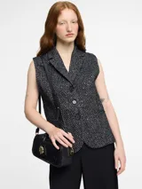 Chaleco sastrero negro con solapa y botones en la parte delantera. Textura con bordados metálicos.