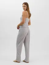 Set de pijama de tres piezas en color verde menta con estampado floral sutil, compuesto por una camisa de manga corta con botones, una musculosa básica y un pantalón largo de corte recto con cordón ajustable en la cintura.