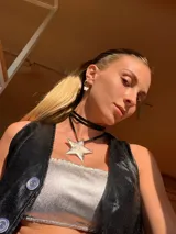 Gargantilla de cuero negro con dije plateado en forma de estrella.