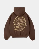 Canguro oversize color marrón con capucha y bolsillo frontal. Presenta un estampado gráfico circular en la espalda con tipografía estilizada en color crema.