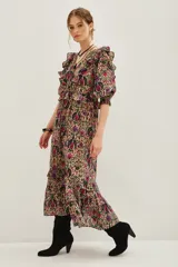 Vestido midi de algodón con estampado floral y geométrico en tonos tierra, fucsia y verde. Presenta escote en V, mangas abullonadas con volados en los hombros y falda con volados en el ruedo.