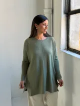 Sweater de tejido de punto color verde oliva, con cuello redondo, mangas largas y corte holgado con costura central vertical.