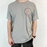 Remera gris de algodón con estampa circular en el pecho con texto y logo en color naranja.