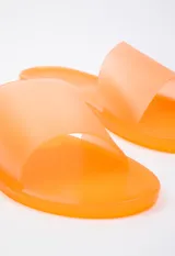 Sandalia chata color negro de goma semi transparente con tira ancha sobre el empeine.