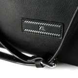 Cartera tipo tote de símil cuero color negro, con doble asa corta y correa larga regulable extraíble. Tiene tres compartimentos internos, uno con cierre, y cierre principal con botón imantado.