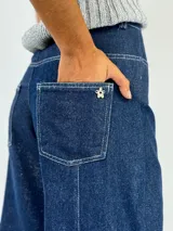 Pantalón de jean de tiro alto, corte palazzo y acabado laminado dorado.