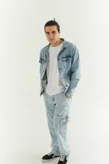 Campera de jean celeste claro con cuello clásico, cierre frontal con botones metálicos, bolsillos con solapa abotonada en el pecho y bolsillos laterales.