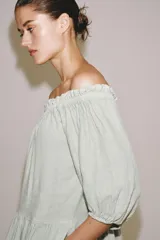Vestido midi confeccionado en lino 100%, con escote recto elástico estilo hombros descubiertos, mangas abullonadas y detalle de pliegues en la cintura. Cuenta con bolsillos laterales ocultos y bajo asimétrico.