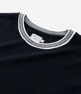 Remera regular de manga corta y cuello redondo color negro, con diseño texturizado y detalles de rayas contrastantes en cuello y puños.