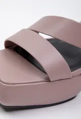 Sandalia de taco alto y plataforma con diseño de tiras anchas en la capellada y cierre mediante hebilla metálica en el tobillo.