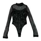 Body de manga larga con diseño estilo gótico, confeccionado en tela de encaje negro con paneles de terciopelo. Presenta un estampado frontal en color blanco con motivos ornamentales y una cruz central. Posee cuello alto y ajuste slim fit.