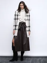 Falda midi marrón de cuero sintético, corte evasé, con abertura lateral y lazo en la cintura.