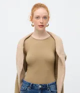 Body de manga larga con cuello redondo, confeccionado en tejido de poliamida y elastano sin costuras. Presenta un diseño ajustado al cuerpo con cierre inferior mediante botones de presión.