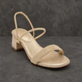Sandalias de taco ancho de 6 cm, color dorado con acabado brillante. Cuentan con una tira frontal ancha cubierta de strass, una tira en el empeine y una tira trasera ajustable.