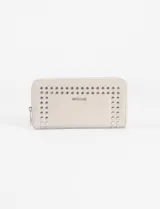 Billetera rectangular de cuero sintético color beige, con cierre perimetral y detalle de tachas metálicas plateadas en la parte frontal.