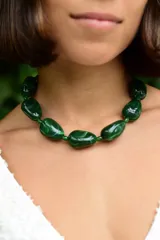 Collar tipo gargantilla compuesto por cuentas de resina en color verde con efecto marmolado. Incluye cadena de alargue de acero inoxidable para ajustar la altura.
