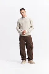 Sweater de algodón con cuello redondo, diseño de calce relajado y hombros caídos. Presenta una textura sutil en el tejido y un logo bordado discreto.