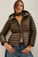 Campera puffer entallada de color verde militar, con cierre frontal, capucha ajustable y diseño acolchado horizontal.