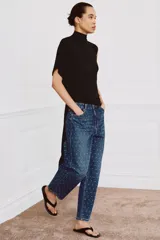 Jeans de tiro medio con corte tapered y largo al tobillo. Presenta un diseño de cinco bolsillos, cierre frontal con cremallera y botón, y un estampado de lunares a contraste sobre un tejido denim con efecto lavado.