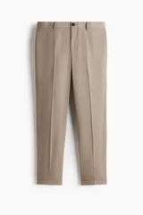 Pantalón sastrero de corte slim fit color beige, con cierre frontal y botón, bolsillos laterales, raya marcada en las piernas y botamanga con dobladillo.
