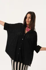 Camisa negra de tejido calado, con escote en V, abotonada y manga 3/4.