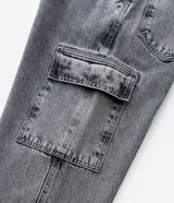 Pantalón de jean gris con efecto acid wash, modelo baggy de corte ancho, cintura con trabillas y bolsillos cargo en los laterales.