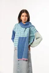 Bufanda tejida a crochet con diseño a cuadros en celeste y azul.