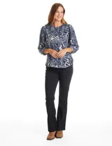 Buzo de tejido soft con estampado floral en tonos azules sobre base gris. Presenta cuello redondo, mangas largas con hombros ligeramente abullonados y puños fruncidos.