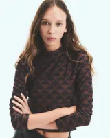 Polera marrón con estampado geométrico de triángulos y monogramas. De cuello alto y mangas largas.