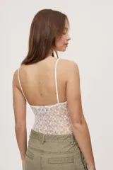 Body de encaje con calce ajustado, escote en V y breteles finos regulables. El diseño combina transparencias y textura floral, con copas forradas que aportan mayor cobertura y un acabado delicado.