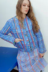 Campera corta de nylon impermeable con estampado a cuadros en tonos azul, blanco y naranja.