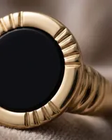 Anillo de plata y oro 18k con diseño central redondo y piedra de ónix negra.