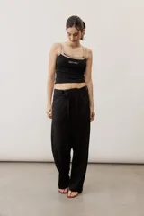 Pantalón de corte ancho y holgado, de color negro, con diseño estructurado y cinturón ajustable integrado en la cintura.