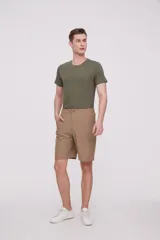 Bermuda de corte recto y diseño minimalista, confeccionada en tejido técnico de poliéster. Presenta cintura elástica con cierre de botón frontal, bolsillos laterales y un bolsillo pequeño adicional en el lateral izquierdo.