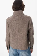 Chaqueta corta de paño color gris, con cuello alto, cierre frontal con cremallera y bolsillos delanteros con solapa.
