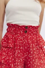 Short rojo con estampado floral blanco, cintura elastizada con volados y bolsillos laterales con solapa.