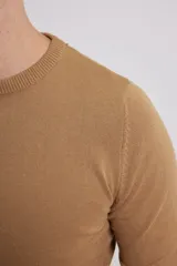 Sweater de punto liso, color azul, con escote redondo y manga larga.